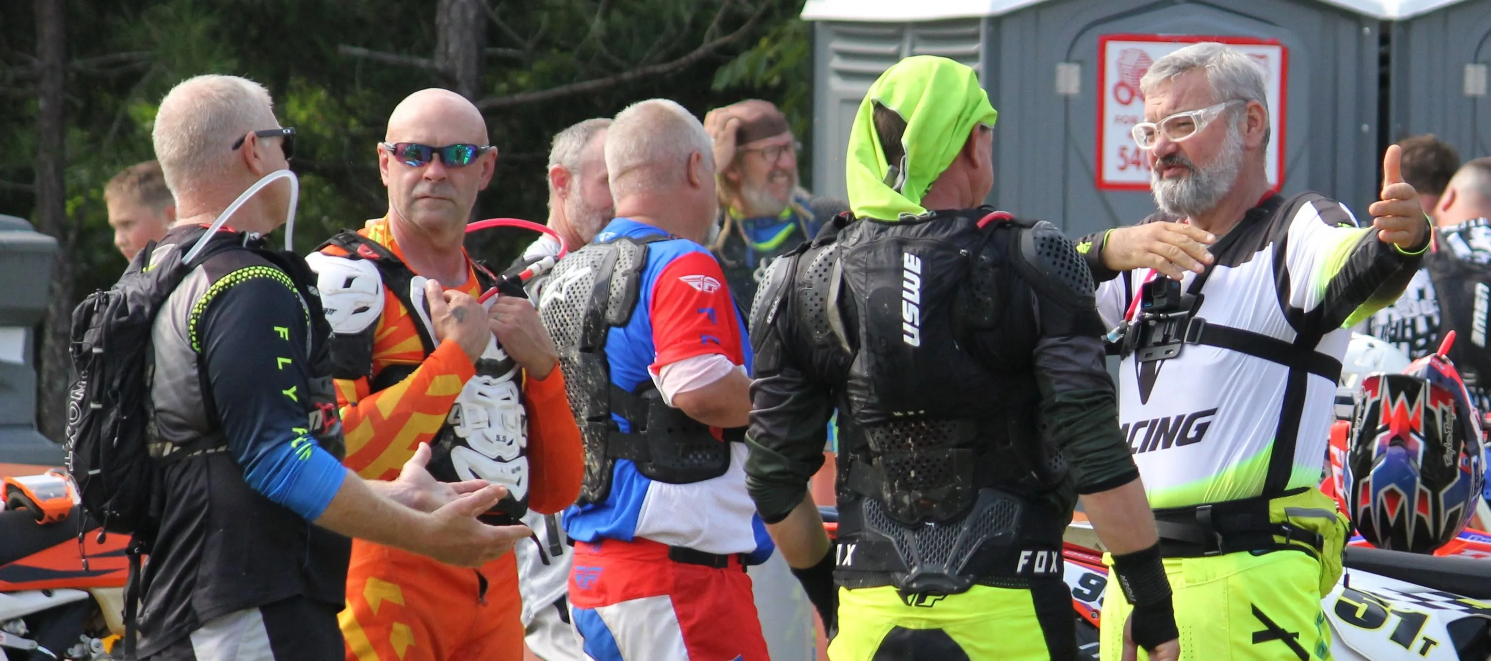 Riders in race gear talking and joking together before the start