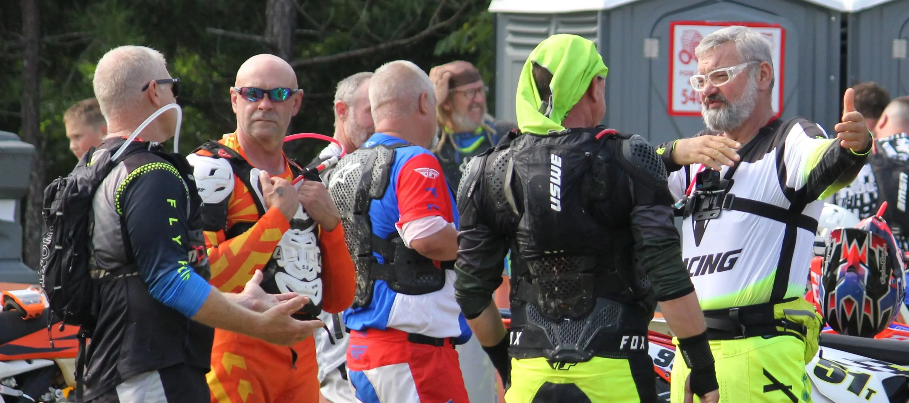 Riders in race gear talking and joking together before the start