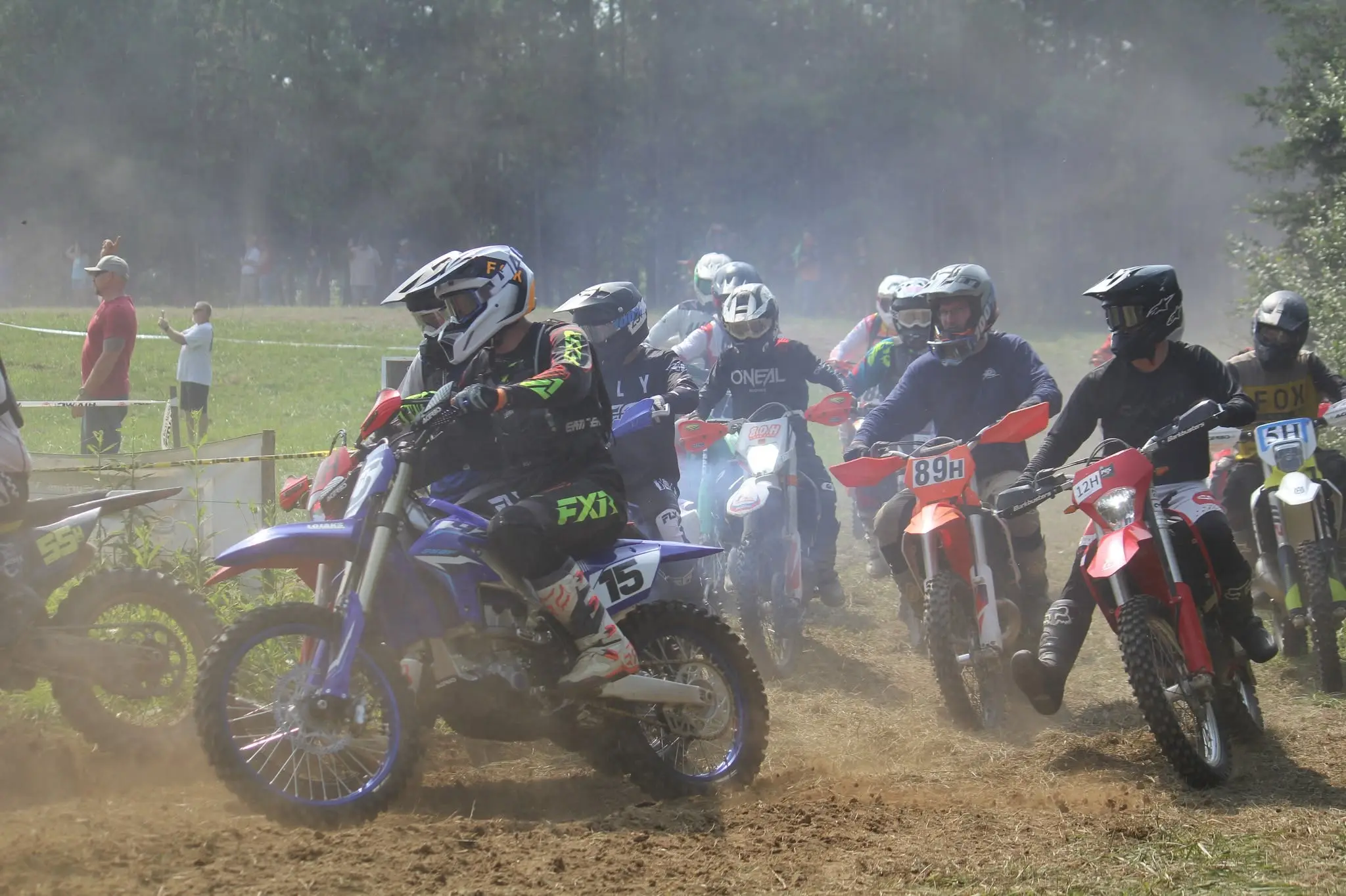 Riders side by side launching off the start, rider 15 at the front of the pack