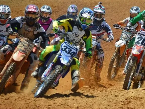 Dakota leading the pack on #334 through the first turn, riders either side of him in the red clay